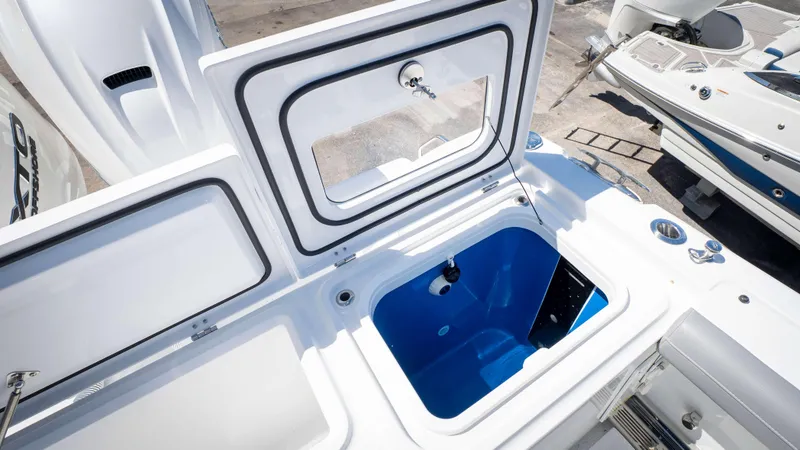 Slide: The Image of Open storage compartment on 2025 Everglades 335 CC boat, featuring a blue interior. - 44