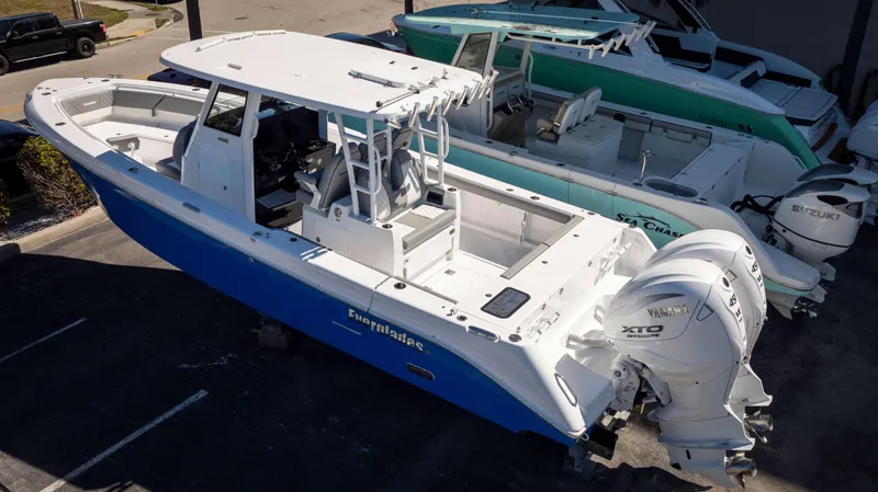 Slide: The Image of 2025 Everglades 335 CC boat with Yamaha engines, parked in a marina. - 5