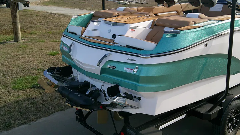 Slide: The Image of 2025 MasterCraft X24 boat on trailer, featuring teal and white design with tan seating. - 3