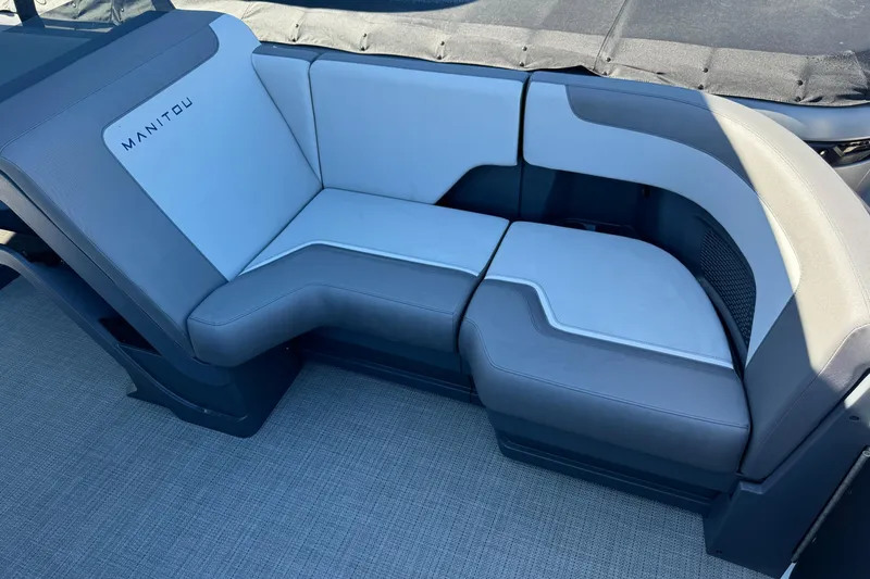 Slide: The Image of 2024 Manitou 22' Cruise Max Switchback boat seating, featuring modern gray upholstery. - 12