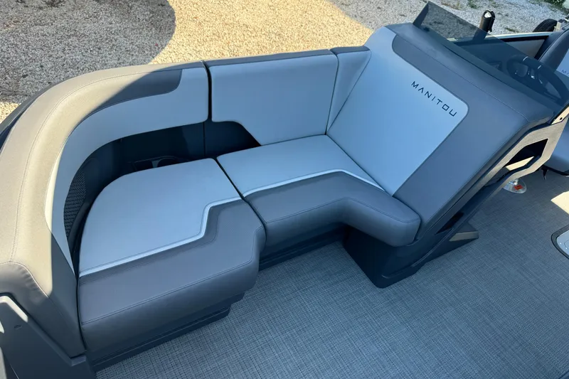 Slide: The Image of 2024 Manitou 22' Cruise Max Switchback boat seating, featuring sleek gray upholstery. - 13