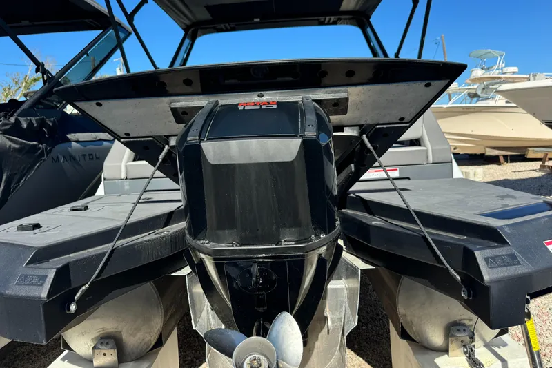 Slide: The Image of 2024 Manitou 22' Cruise Max Switchback boat engine and stern view. - 18