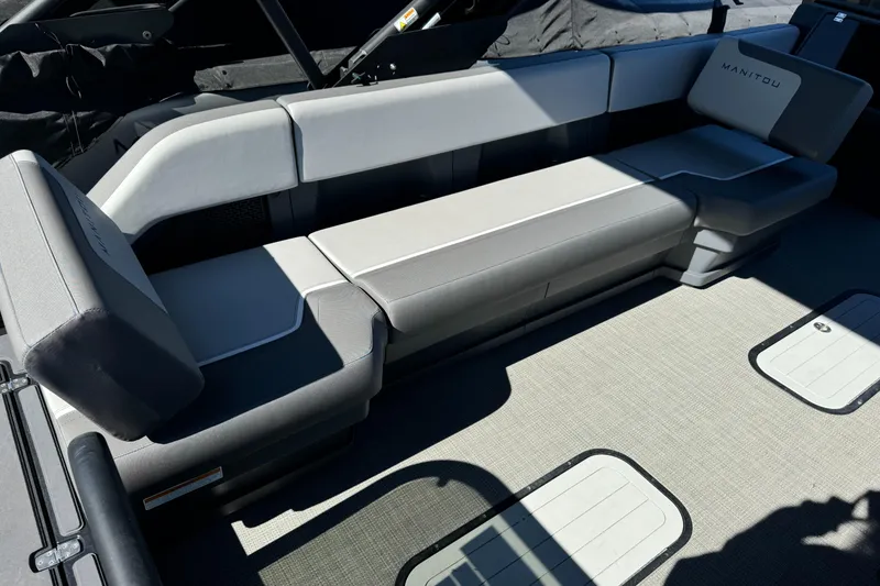 Slide: The Image of 2024 Manitou 22' Cruise Max Switchback boat interior with sleek gray seating. - 2