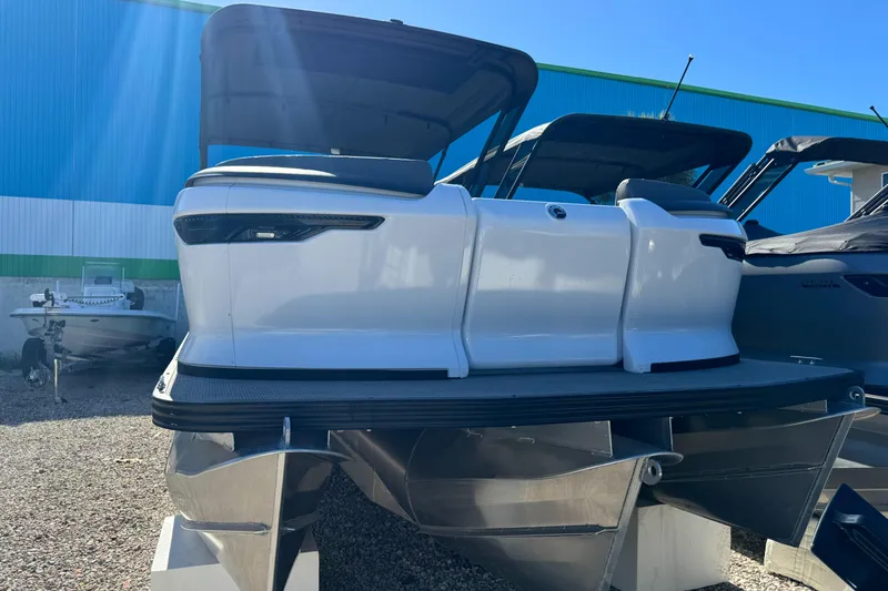 Slide: The Image of 2024 Manitou 22' Cruise Max Switchback pontoon boat, sleek design, displayed outdoors. - 20