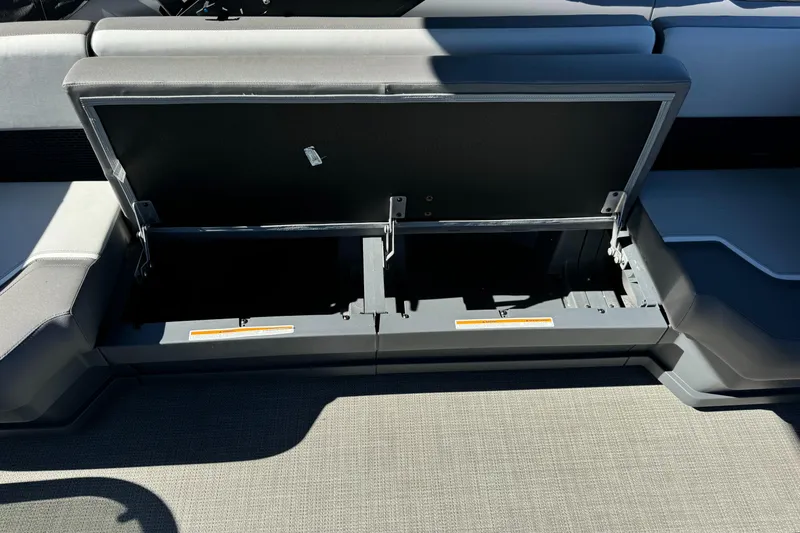 Slide: The Image of 2024 Manitou 22' Cruise Max Switchback storage compartment open, showcasing spacious interior. - 6