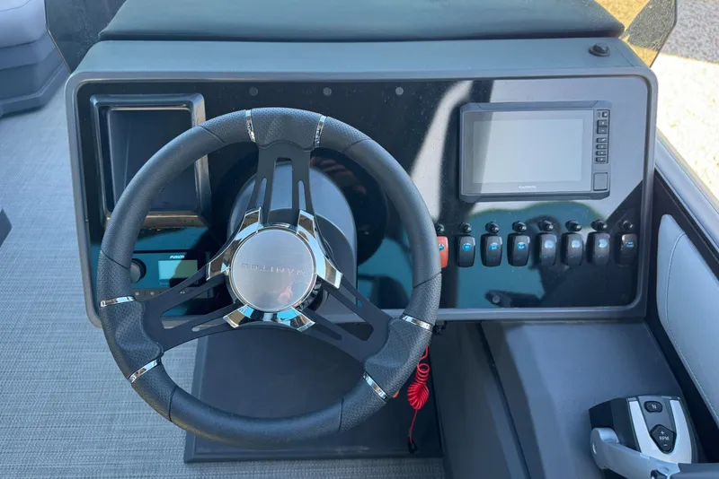 Slide: The Image of 2024 Manitou 22' Cruise Max Switchback dashboard with steering wheel and control panel. - 9