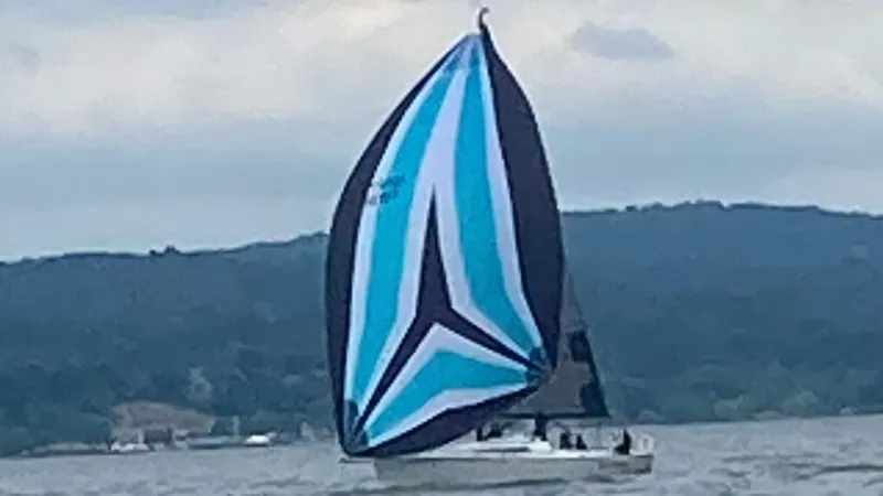 Slide: The Image of Sailboat with blue and black spinnaker on a lake, Tartan 101 model, 2013. - 1