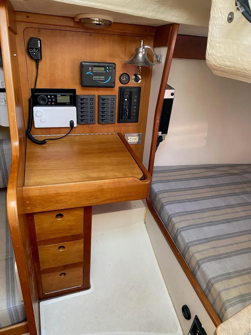 Slide: The Image of 2013 Tartan 101 sailboat interior with navigation station and striped bedding. - 14