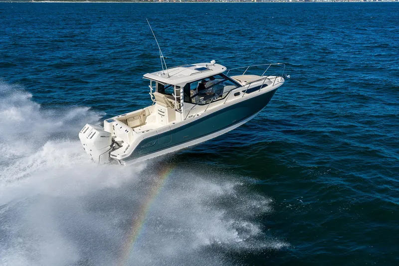 Slide: The Image of 2025 Boston Whaler 325 Conquest cruising on open water, creating a splash and rainbow effect. - 0