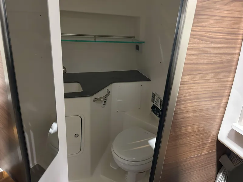 Slide: The Image of 2025 Boston Whaler 325 Conquest bathroom with modern fixtures and wood accents. - 19