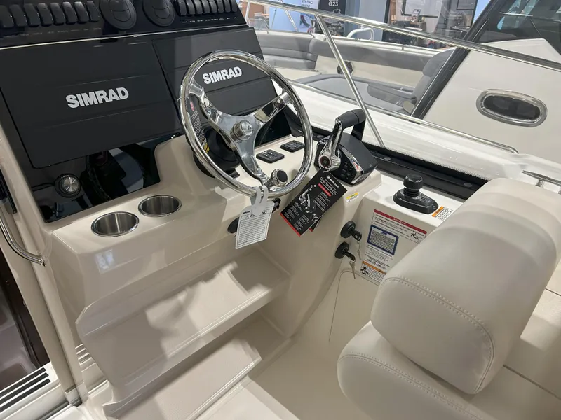 Slide: The Image of 2025 Boston Whaler 325 Conquest helm with Simrad electronics and modern steering wheel. - 21