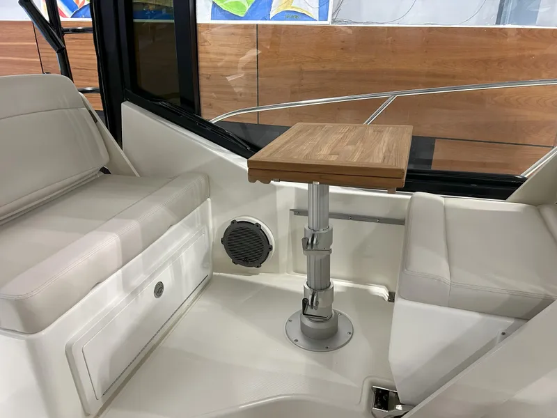 Slide: The Image of 2025 Boston Whaler 325 Conquest interior with seating and wooden table. - 31