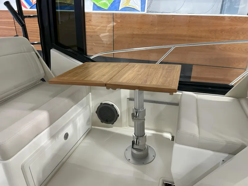 Slide: The Image of 2025 Boston Whaler 325 Conquest interior with wooden table and white seating. - 33