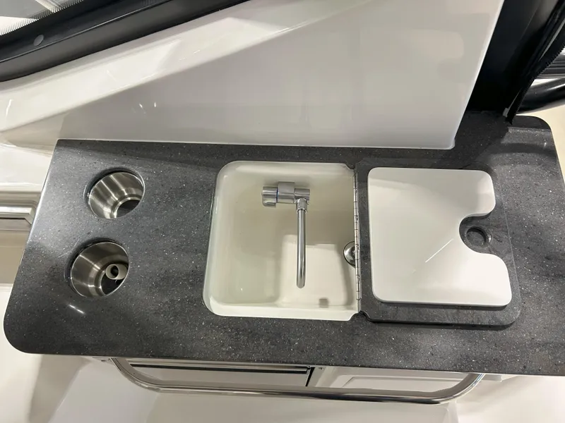 Slide: The Image of 2025 Boston Whaler 325 Conquest boat sink and countertop with integrated cup holders. - 37