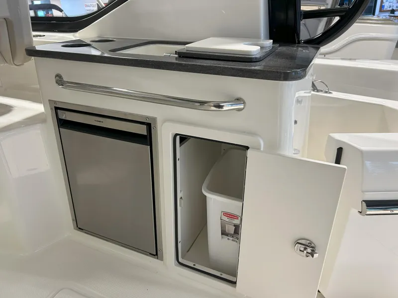 Slide: The Image of 2025 Boston Whaler 325 Conquest galley with fridge and storage compartment. - 40