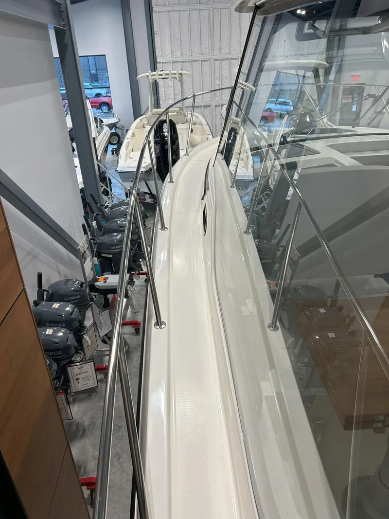 Slide: The Image of 2025 Boston Whaler 325 Conquest boat in showroom, side view with sleek design. - 47