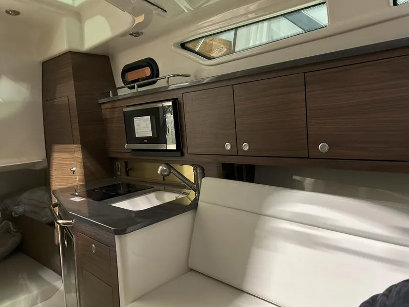 Slide: The Image of Interior of 2025 Boston Whaler 325 Conquest, featuring modern kitchen and seating area. - 8