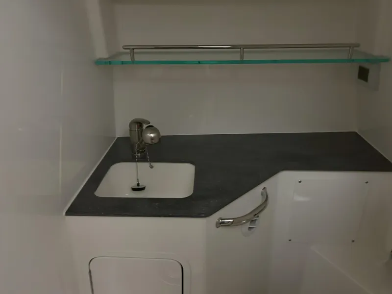 Slide: The Image of 2025 Boston Whaler 325 Conquest interior sink area with modern design and sleek countertop. - 9