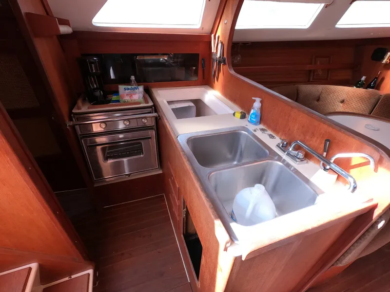 Slide: The Image of Galley kitchen in 1984 Freedom 32 sailboat with stove, sink, and wooden cabinetry. - 10