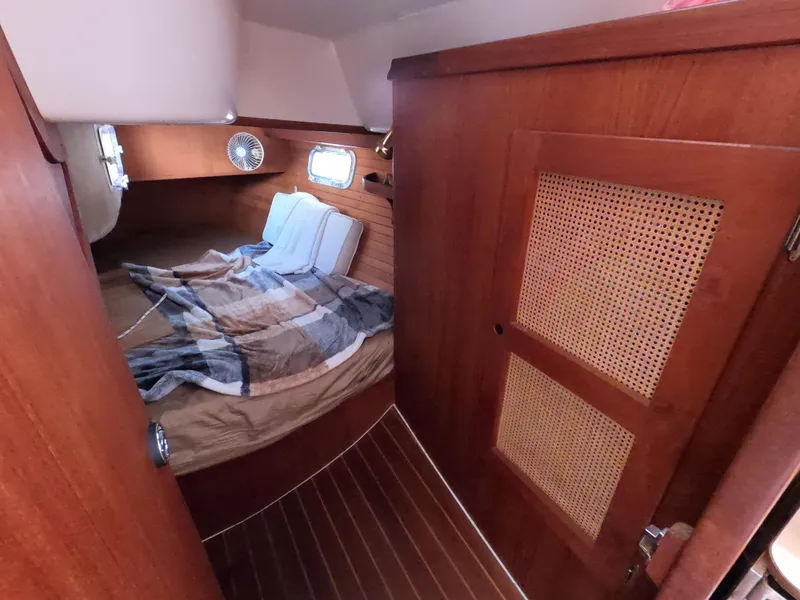 Slide: The Image of Cozy cabin interior of 1984 Freedom 32 sailboat with wooden paneling and bed. - 12