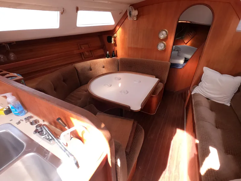Slide: The Image of 1984 Freedom 32 yacht interior with cozy seating and wooden finishes. - 13