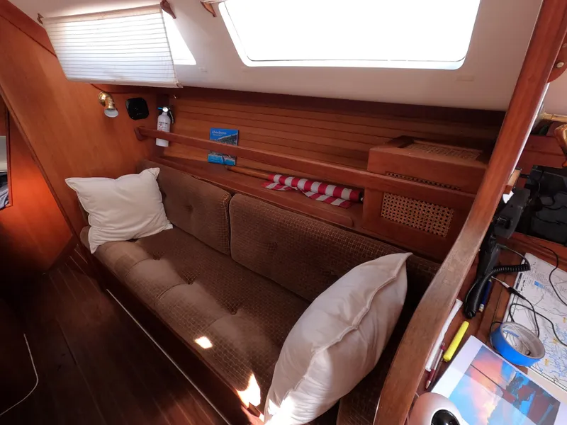 Slide: The Image of Cozy interior of 1984 Freedom 32 sailboat with cushioned seating and wooden accents. - 14