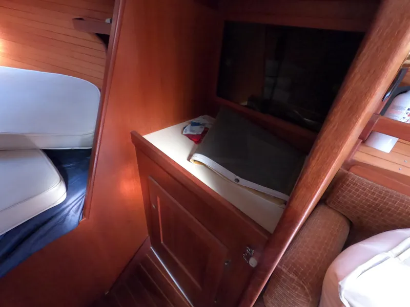 Slide: The Image of Cozy cabin interior of 1984 Freedom 32 sailboat with wooden furnishings and storage space. - 16