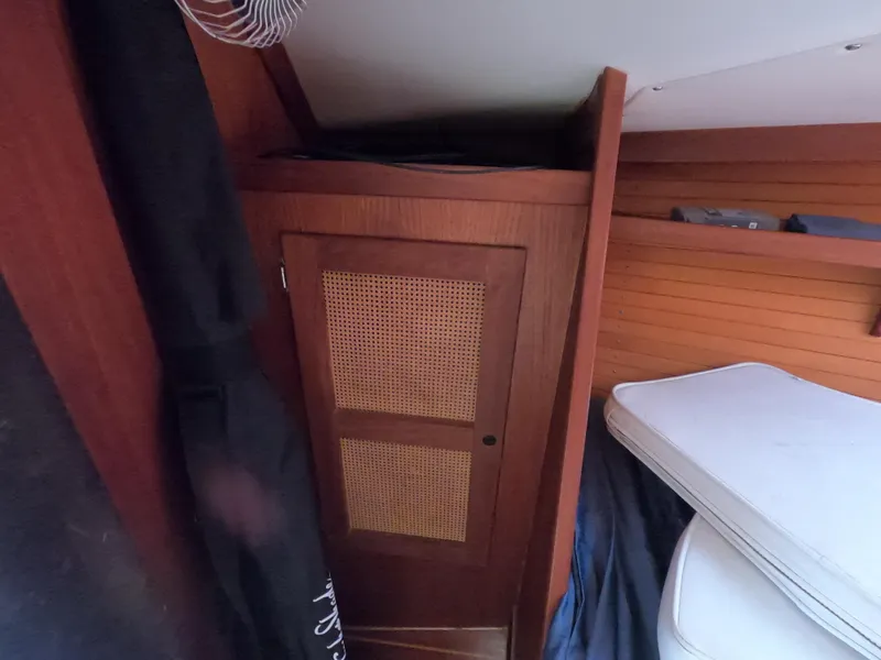 Slide: The Image of Wooden interior of a 1984 Freedom 32 boat with storage and bedding. - 17