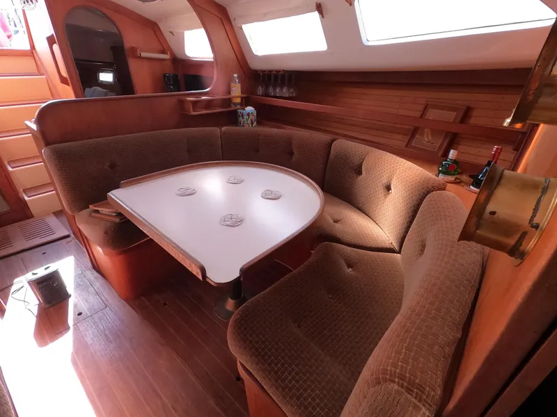 Slide: The Image of Cozy 1984 Freedom 32 sailboat interior with curved seating and wooden accents. - 18