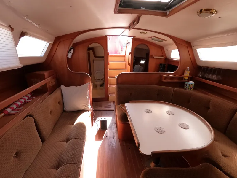 Slide: The Image of Cozy interior of 1984 Freedom 32 sailboat with wooden furnishings and seating area. - 19