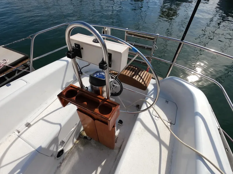 Slide: The Image of Cockpit of 1984 Freedom 32 sailboat with steering wheel and wooden cup holder. - 25