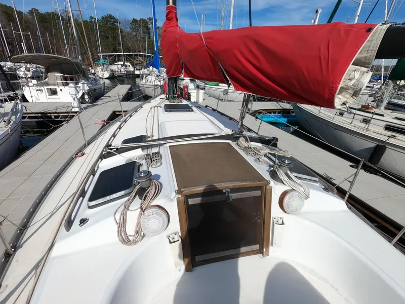 Slide: The Image of 1984 Freedom 32 sailboat with red sail, docked in marina. - 26