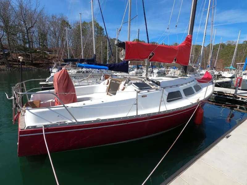 Slide: The Image of Red and white 1984 Freedom 32 sailboat docked at a marina. - 3