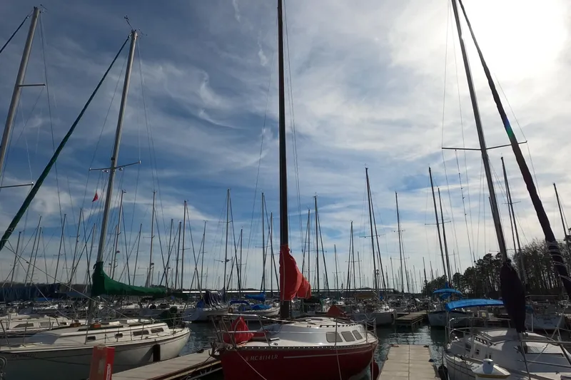 Slide: The Image of Sailboats docked at a marina under a cloudy sky, featuring a 1984 Freedom 32. - 30