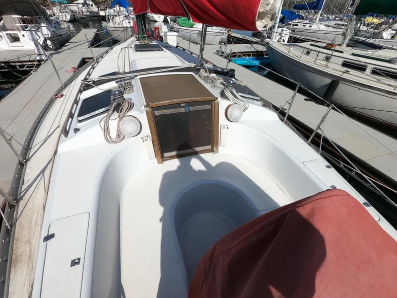 Slide: The Image of 1984 Freedom 32 sailboat deck with red sail cover, docked in marina. - 5