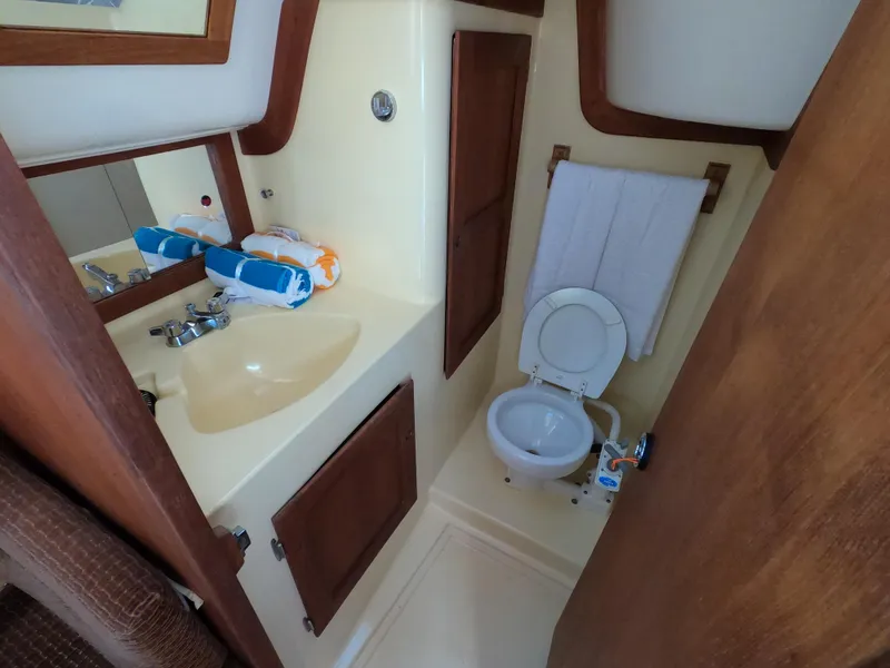 Slide: The Image of Compact boat bathroom with sink, toilet, and towels; Freedom 32, 1984 model. - 9