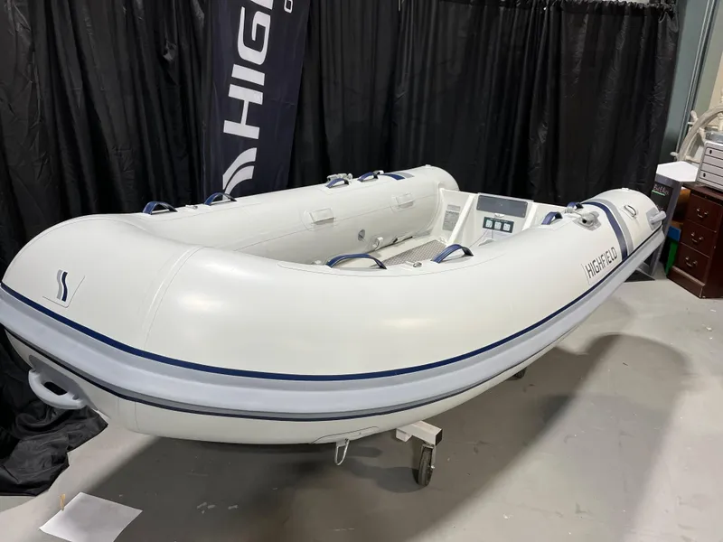 The Image of 2025 Highfield Ultralite 310 inflatable boat displayed indoors on a stand. - 1
