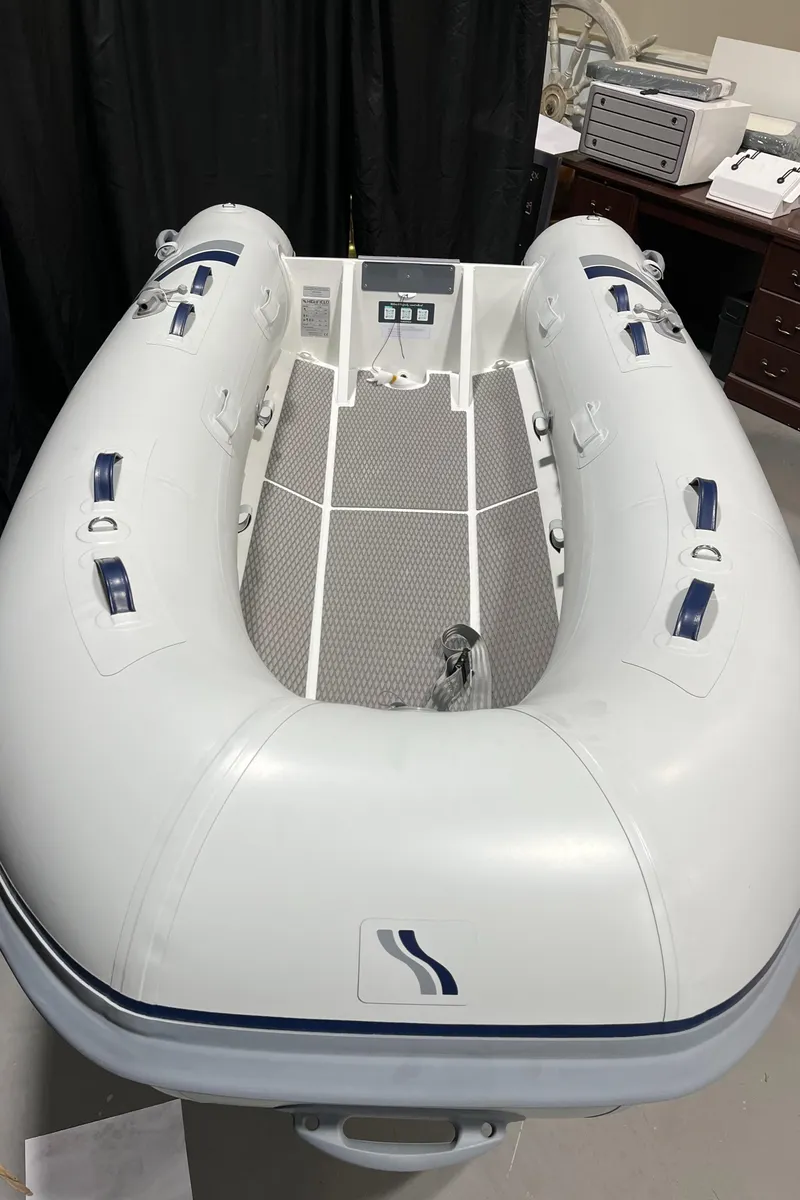 Slide: The Image of 2025 Highfield Ultralite 310 inflatable boat, white, displayed indoors. - 3