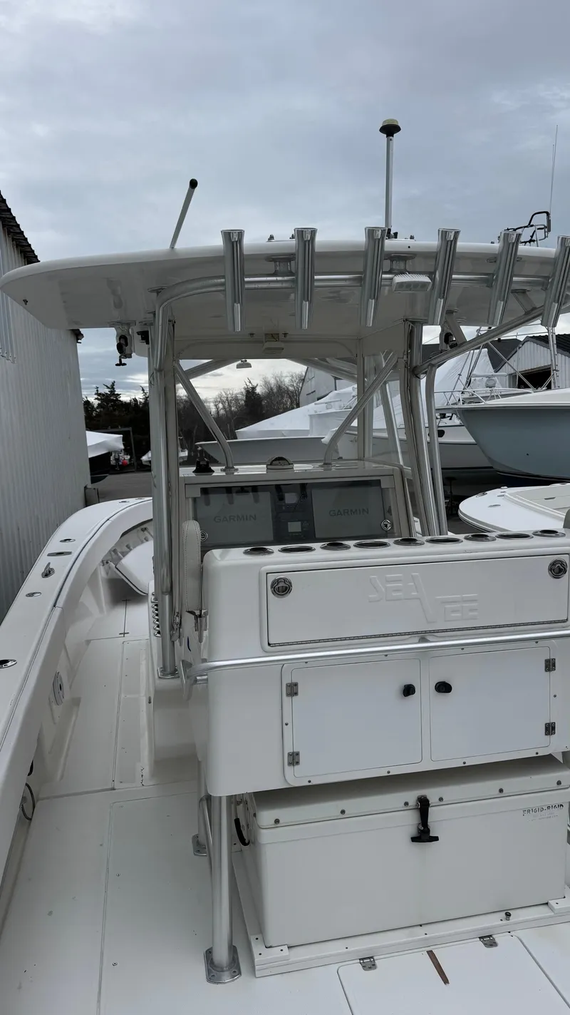 Slide: The Image of 2003 SeaVee 34B boat with center console and rod holders, docked under cloudy skies. - 10