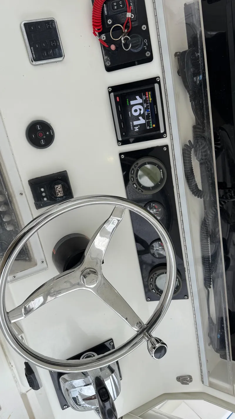 Slide: The Image of 2003 SeaVee 34B boat dashboard with steering wheel and navigation instruments. - 12