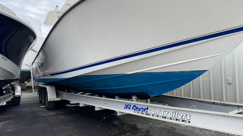 Slide: The Image of 2003 SeaVee 34B boat on trailer, white hull with blue accents, parked outdoors. - 3