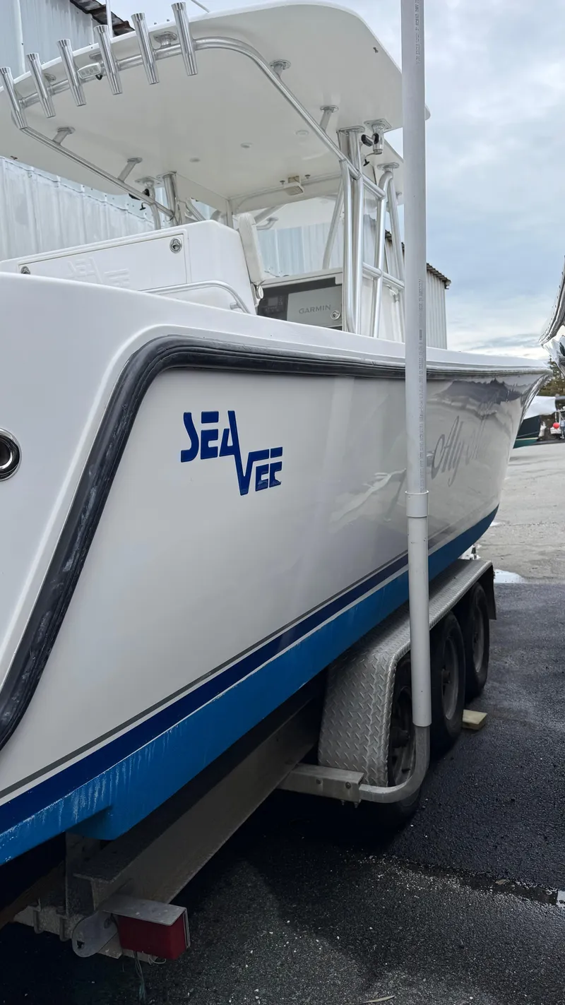 Slide: The Image of 2003 SeaVee 34B boat on trailer, white with blue accents, docked outdoors. - 6