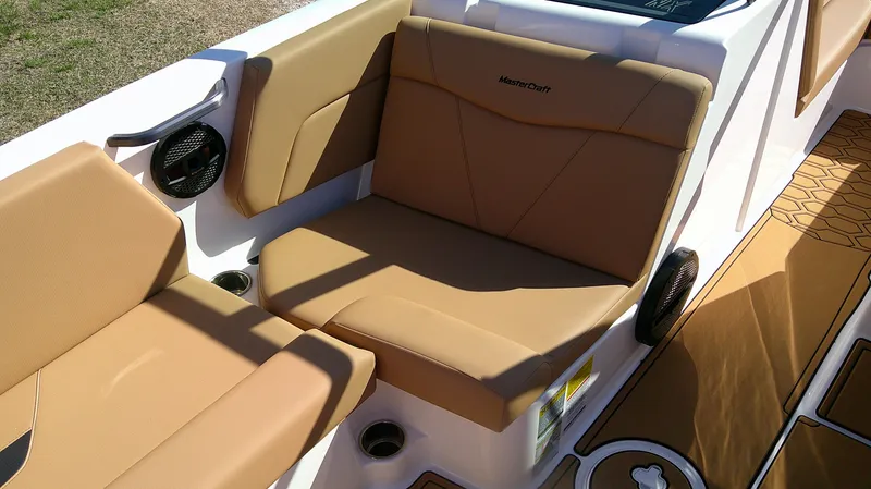 Slide: The Image of 2025 MasterCraft NXT22 boat interior with tan seating and modern design. - 10