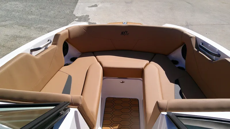 Slide: The Image of 2025 MasterCraft NXT22 boat interior with tan seating and modern design. - 11