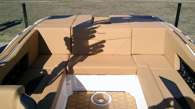 Slide: The Image of 2025 MasterCraft NXT22 boat interior with tan seating and hexagonal flooring design. - 9