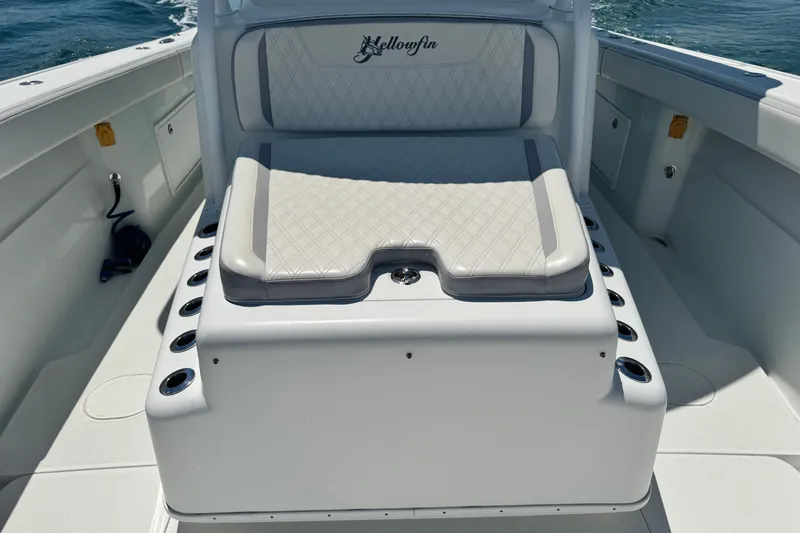 Slide: The Image of 2014 Yellowfin 42 Offshore boat seating area with cushioned bench and rod holders. - 10