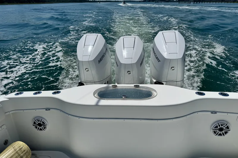 Slide: The Image of 2014 Yellowfin 42 Offshore boat with triple Mercury engines cruising on open water. - 12