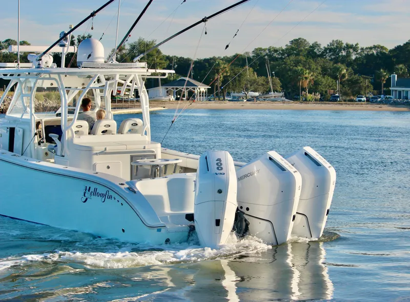 Slide: The Image of 2014 Yellowfin 42 boat with triple outboard engines cruising near the shore. - 5