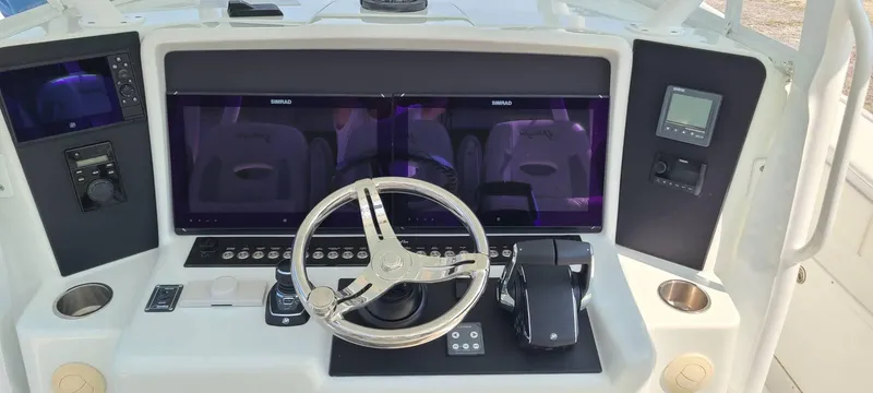 Slide: The Image of 2014 Yellowfin 42 boat dashboard with steering wheel and electronic controls. - 6