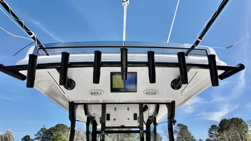Slide: The Image of 2025 Sea Fox 368 Commander boat with rod holders and navigation screen under clear blue sky. - 7